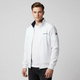 Man wearing a white jacket with a brand logo on a gray background